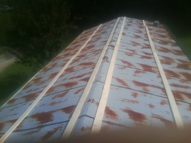 Rusted metal roof panels with new wood purlins before replacement — Storm Damage Roof Repair in Falling Waters by Roofing Brothers