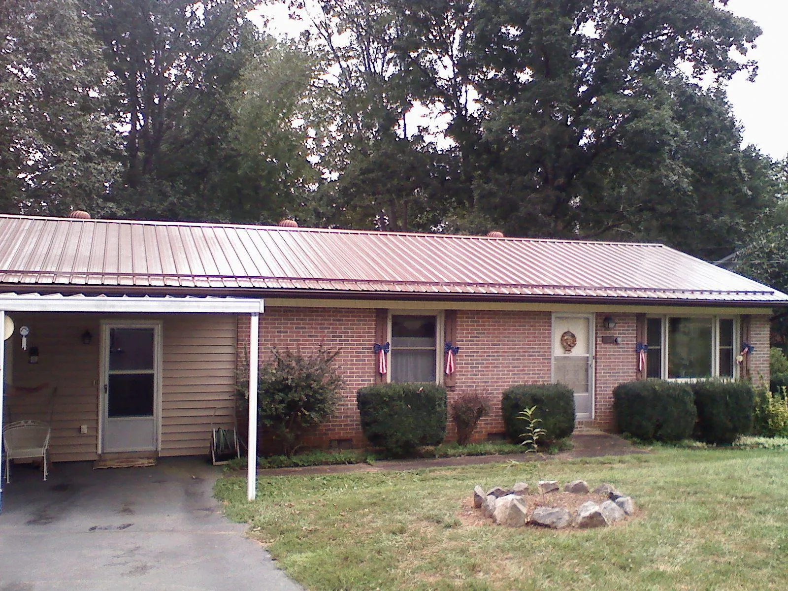 Bronze metal roof and carport on a brick ranch home — Roof Repair work by our crew in Falling Waters