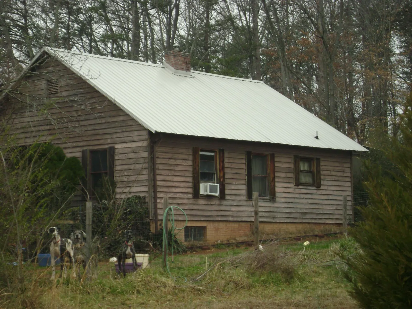 White metal roof on an old wood sided farmhouse, from a Metal Roof Installation job in Falling Waters